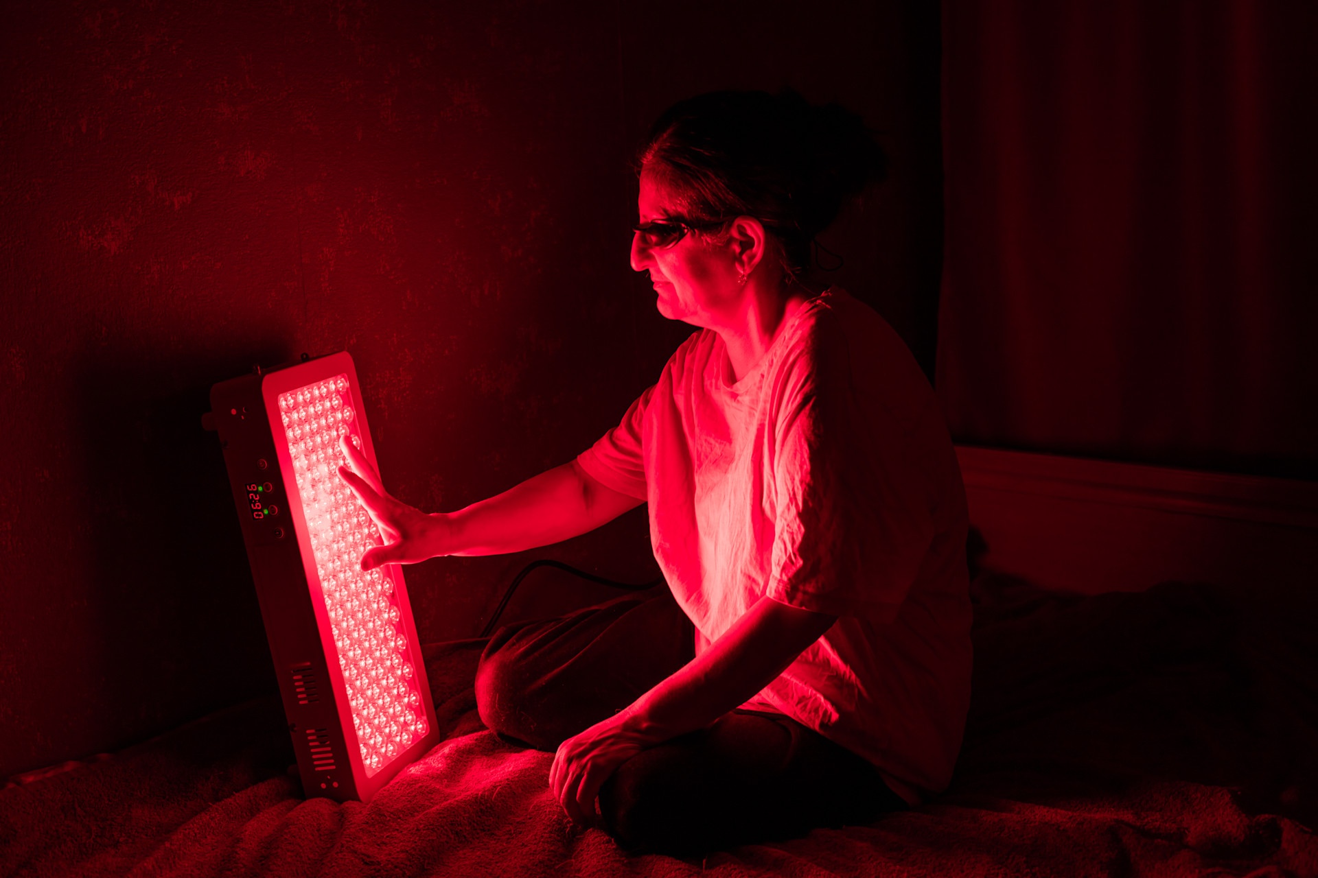 senior-woman-touching-red-light-therapy-panel-leds-2024-01-15-19-50-18-utc