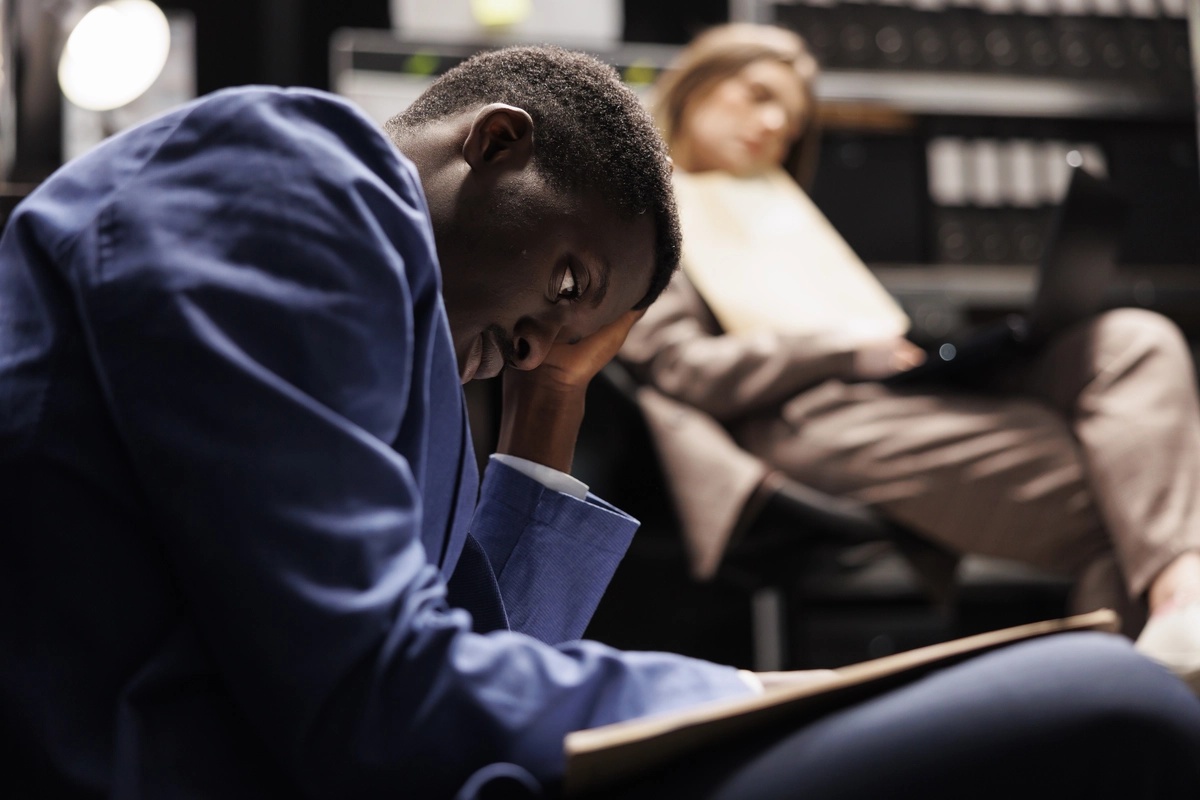 A young man struggling with symptoms of SAD while in a college class.