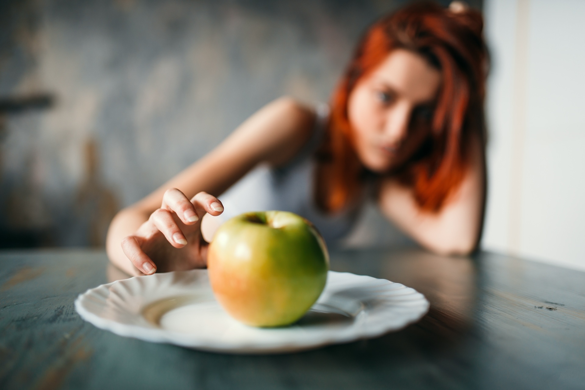 female-hand-reaches-plate-with-apple-2024-12-04-20-20-15-utc