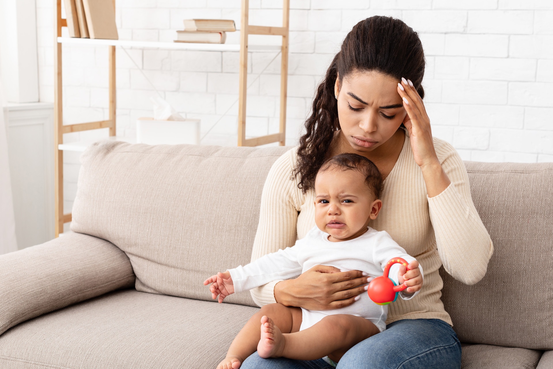 black-mom-having-headache-sitting-with-crying-baby-2024-11-20-16-59-03-utc