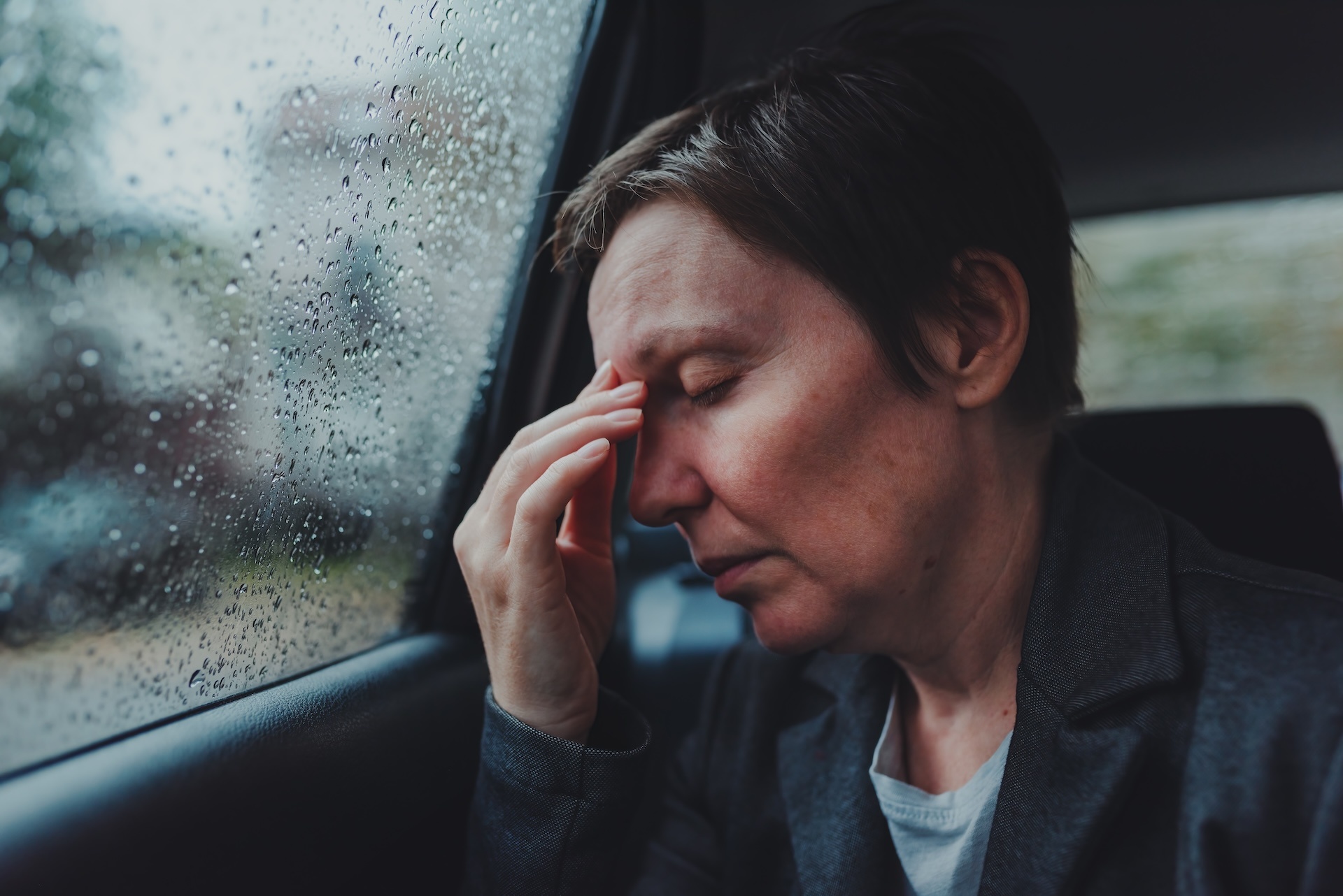 tired-exhausted-businesswoman-at-car-backseat-duri-2024-12-06-16-37-52-utc