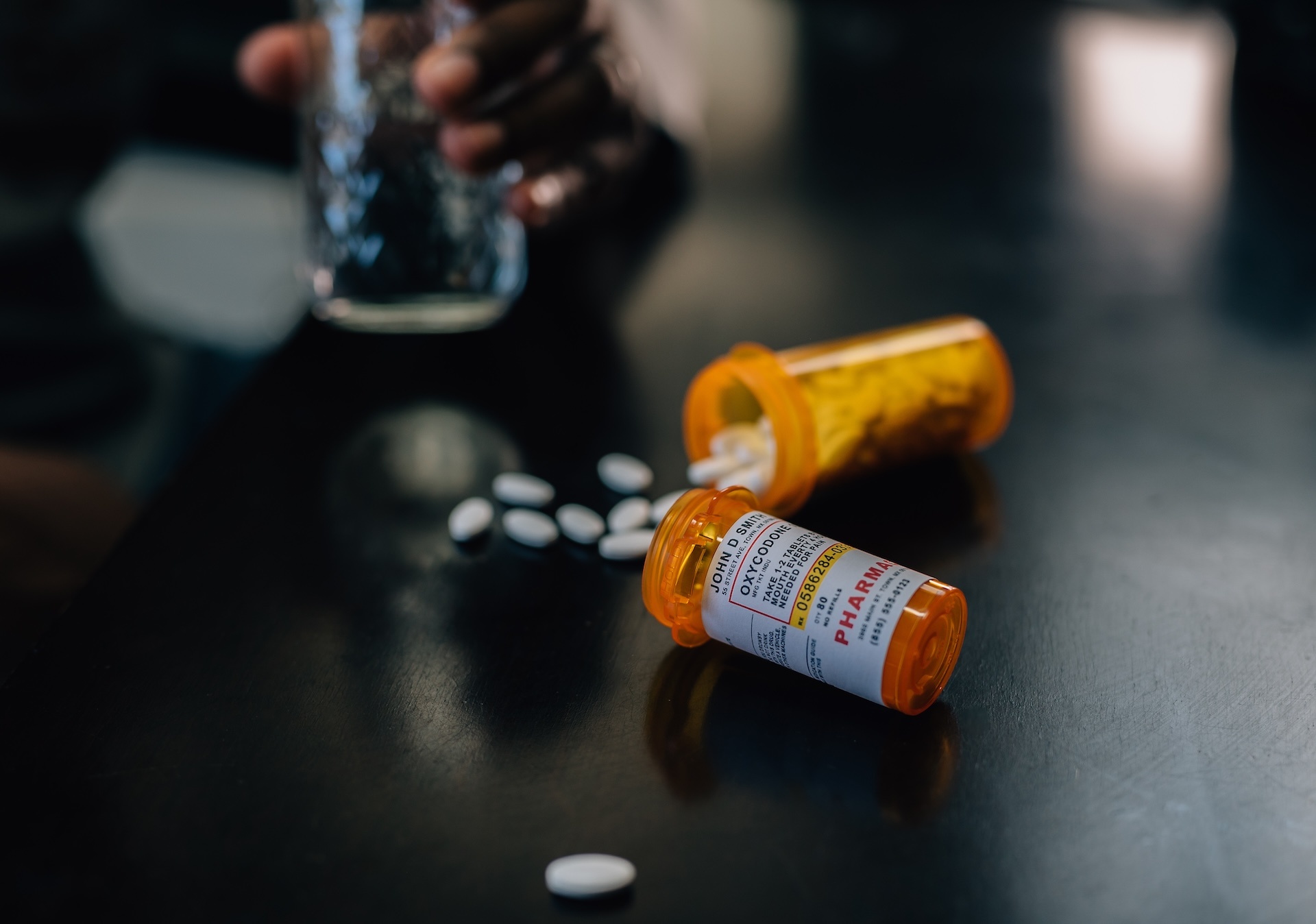 bottles-of-narcotic-pills-spilled-on-table-man-in-2024-09-17-23-07-48-utc