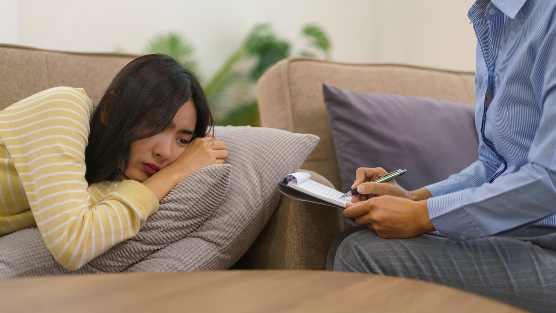 female-depressed-patients-lying-on-couch-and-liste-2023-11-27-05-18-57-utc