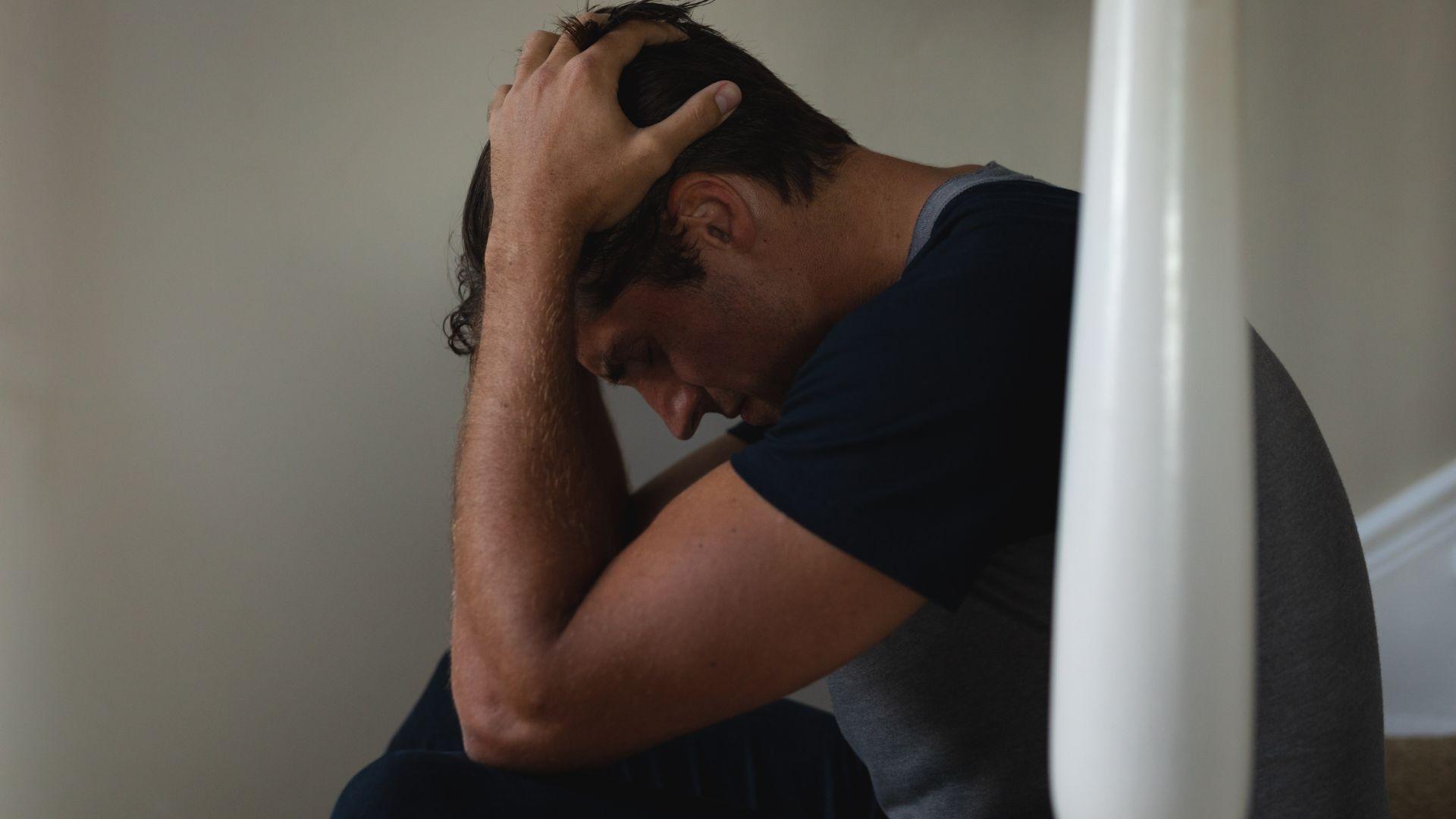 paws addiction: Man on stairs with hands on head in despair