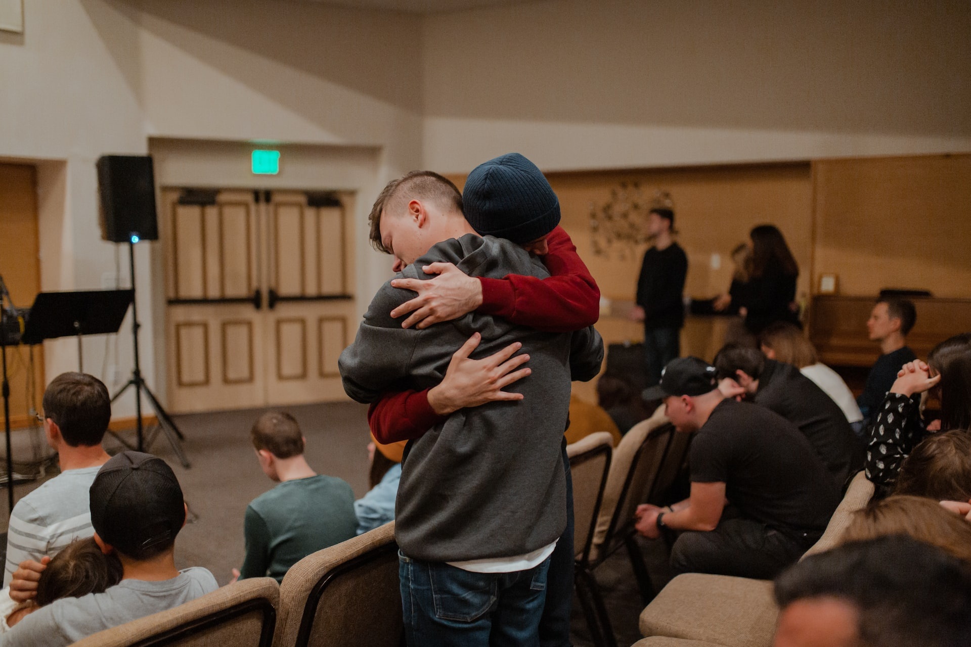 How Do 12-Step Programs Work? Picture of two people hugging at a support group meeting.