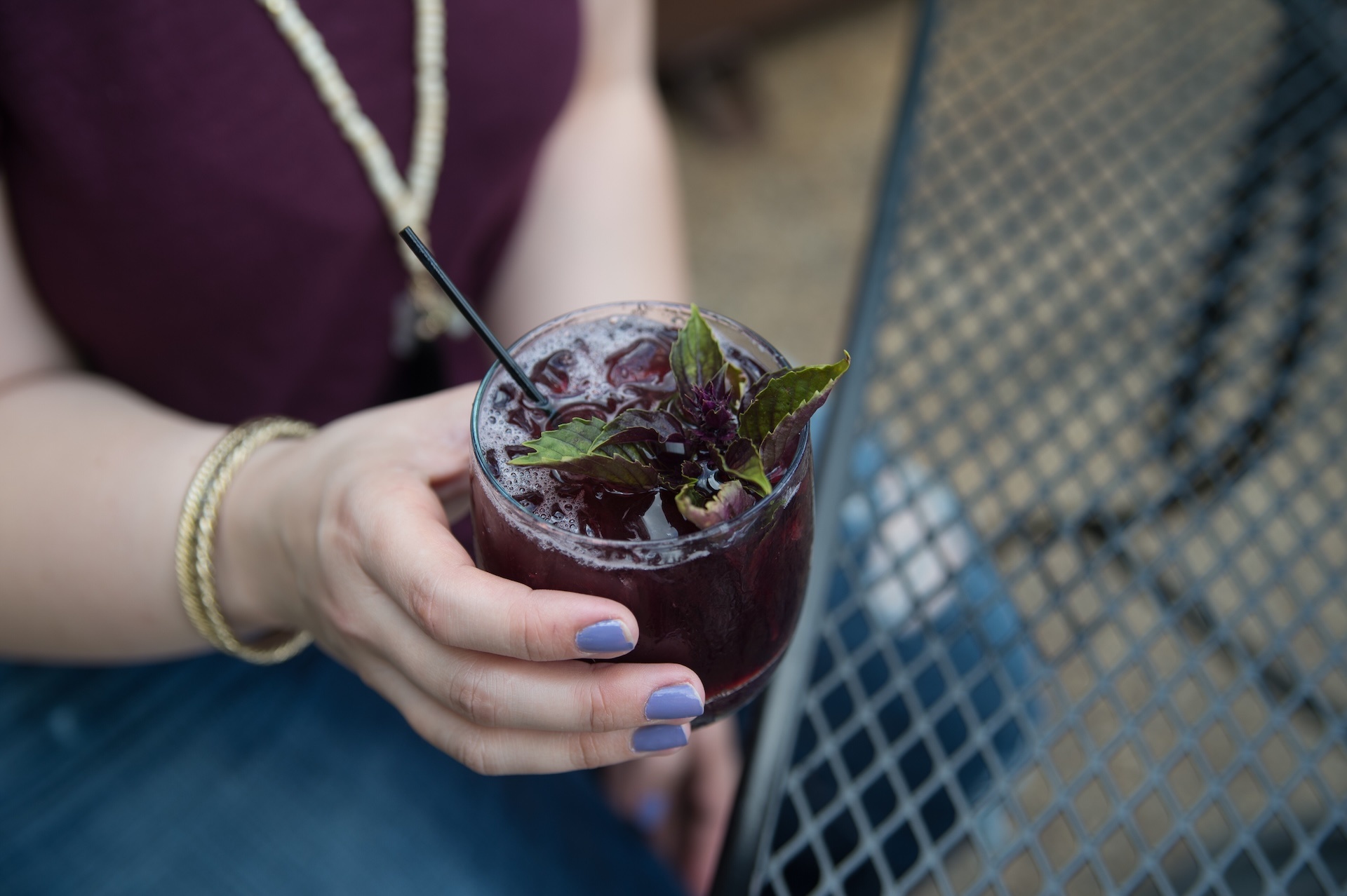 woman-s-hand-holding-dark-purple-cocktail