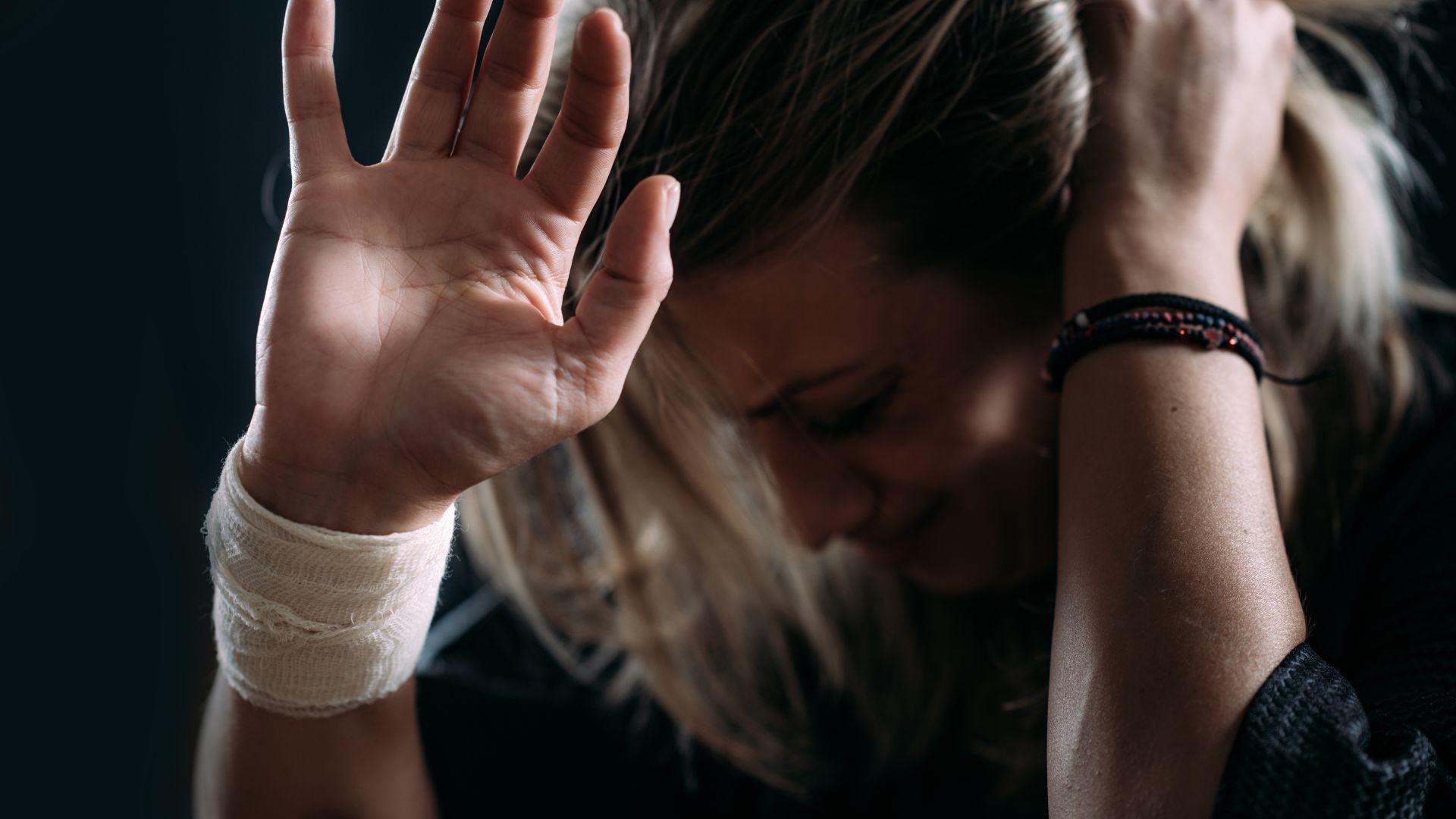 sh addiction: woman in dark room covering her head in fear