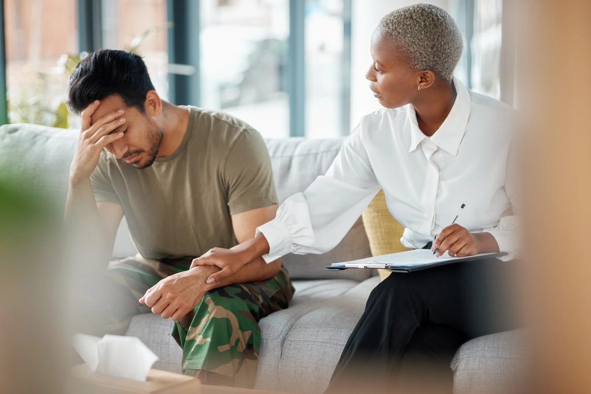 A therapist comforts her client as they sit together on a couch and discuss the possibility of outpatient rehab. A therapist comforts her client as they sit together on a couch and discuss the possibility of outpatient rehab.