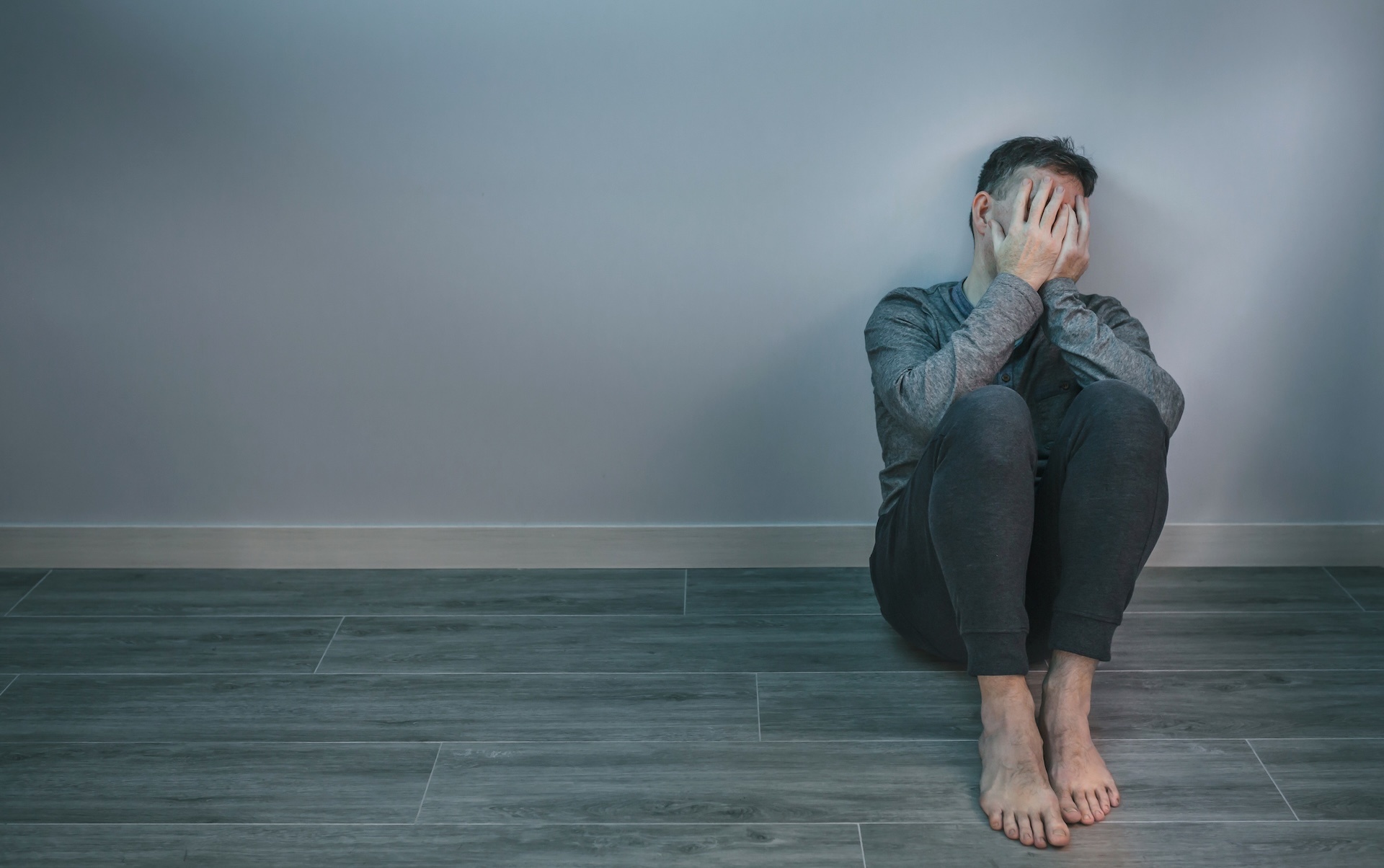 man-crying-while-covering-his-face-with-hands-sitt-2023-11-27-04-52-48-utc