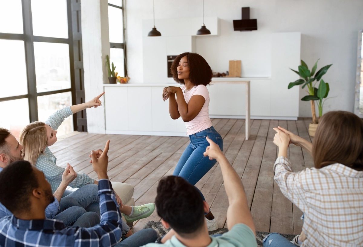 A group of people playing charades in an experiential therapy setting.