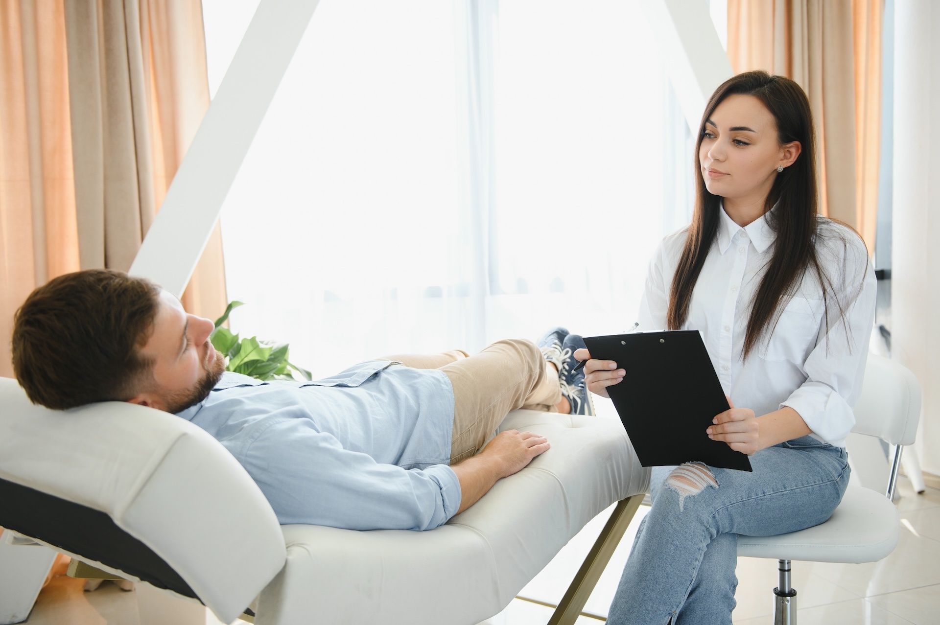 depressed-man-speaking-to-a-therapist-while-she-is-2025-03-13-15-16-32-utc