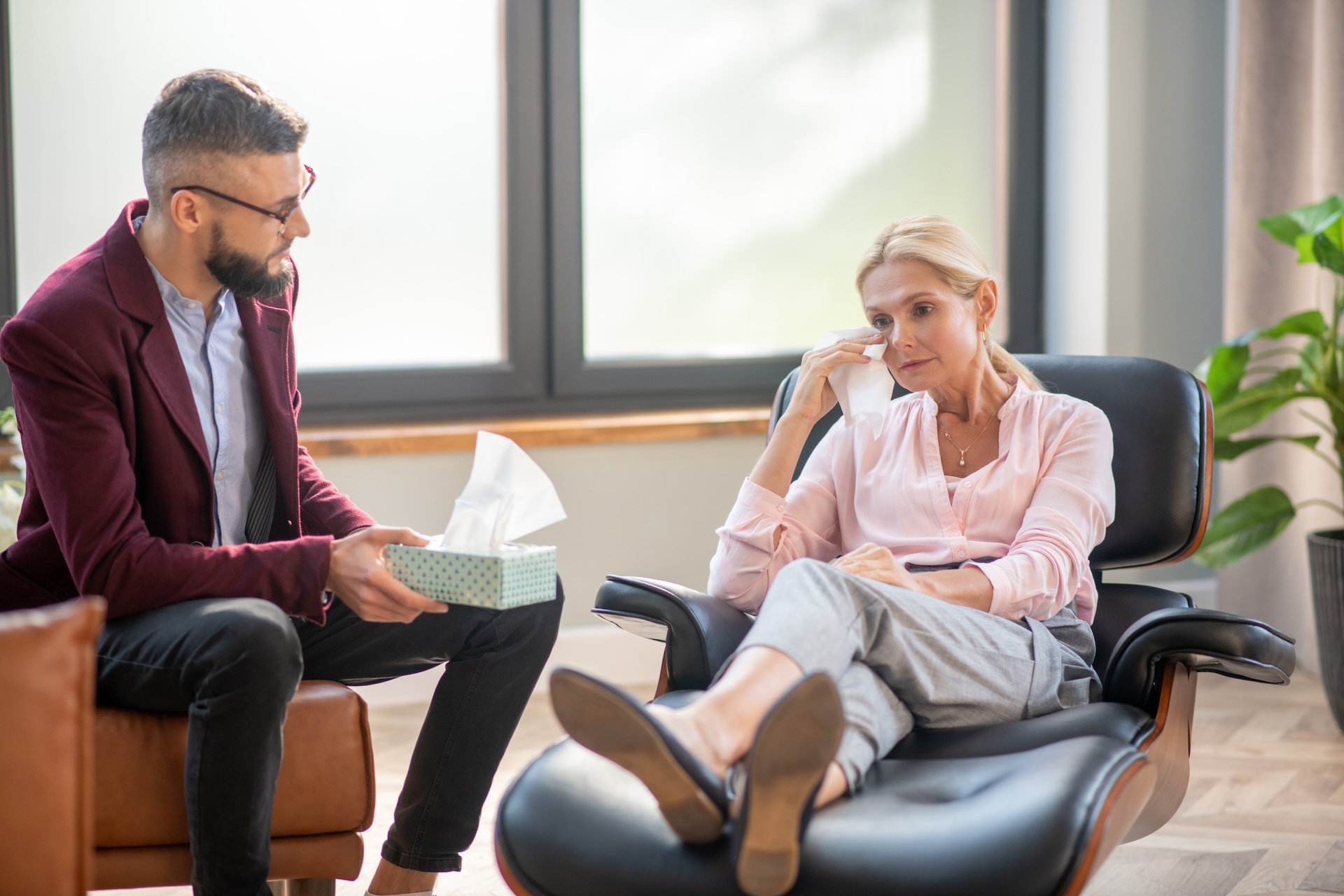 bearded-young-psychologist-speaking-with-crying-wo-2024-10-18-07-45-23-utc