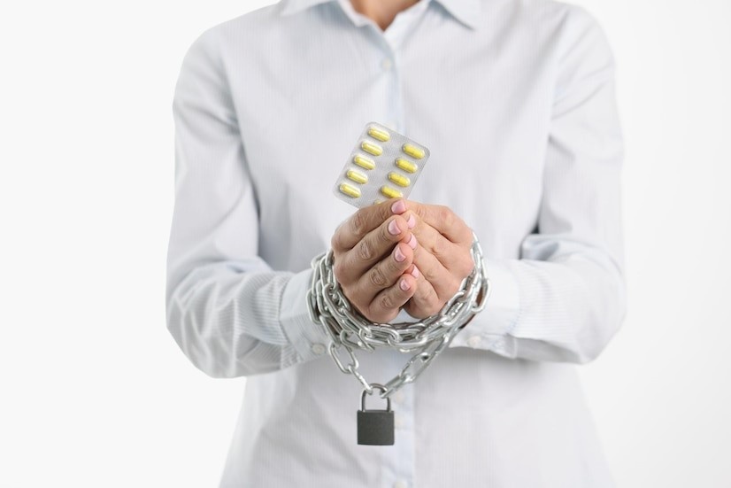 Why Is Opioid Abuse Dangerous? Handcuffed man holding a blister pack of pills.