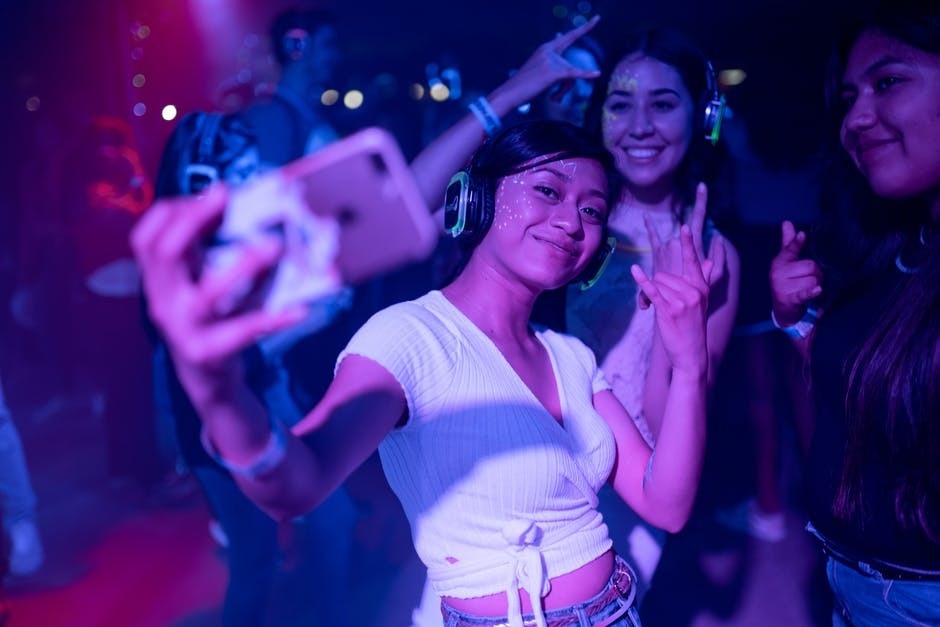 The 4 Stages of Drug & Alcohol Addiction Photo of a woman taking a selfie at a dance club.